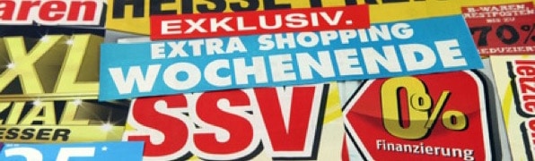 Eine Sammlung bunter deutscher Verkaufsschilder, die für exklusive Angebote, ein zusätzliches Einkaufswochenende und 0 % Finanzierung werben.