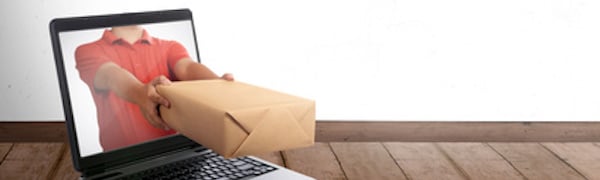 Eine Person in einem roten Hemd streckt ihre Arme durch einen Laptop-Bildschirm und hält ein Papppaket hoch.