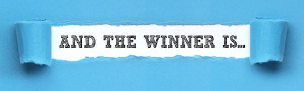 Der Text „AND THE WINNER IS…“ wird durch das Durchreißen einer blauen Papierschicht sichtbar.