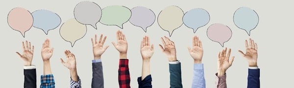 Acht Hände unterschiedlicher Personen sind erhoben, jede unter einer andersfarbigen Sprechblase, als Symbol für Kommunikation oder Teilnahme.