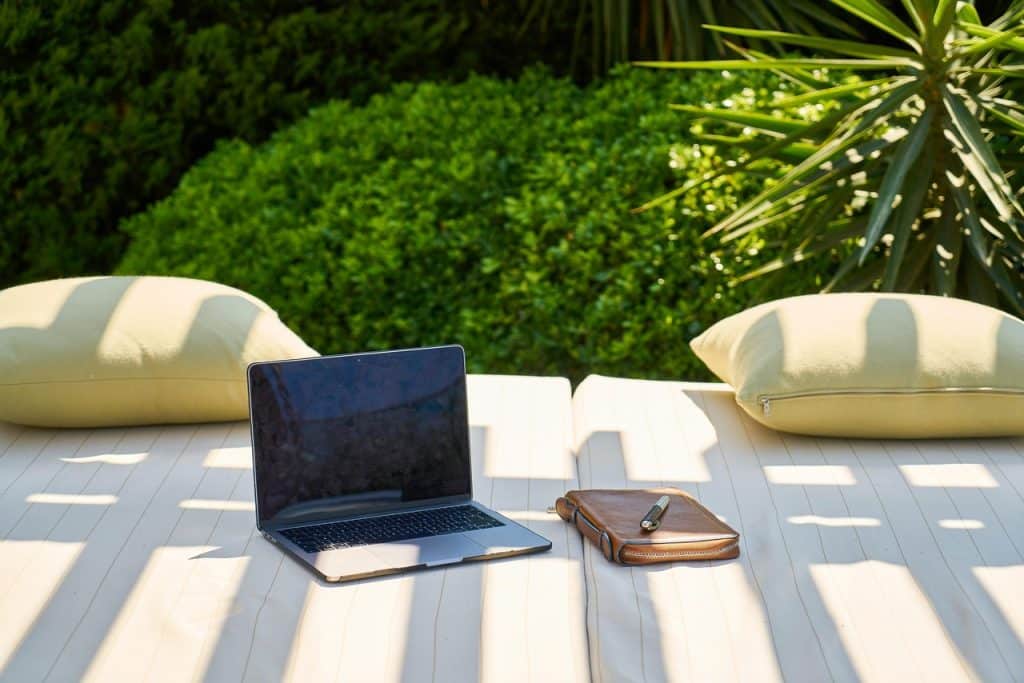 Laptop liegt am Urlaubsort auf einem Tisch — Symbolbild für berufliche Erreichbarkeit im Urlaub
