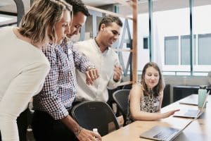 Marketing team discusses a campaign on a laptop