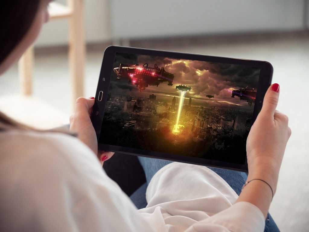 Person haelt ein Tablet mit laufendem Streamingvideo
